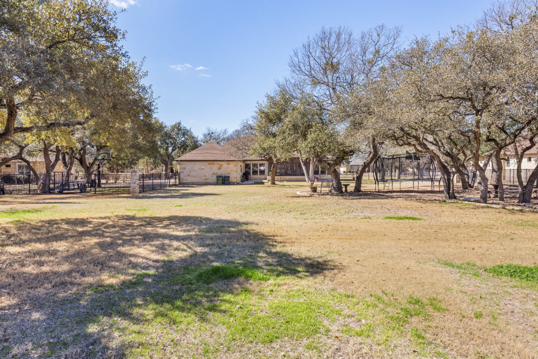 Rear view of home from backyard showing screened patio and pool-ready yard
