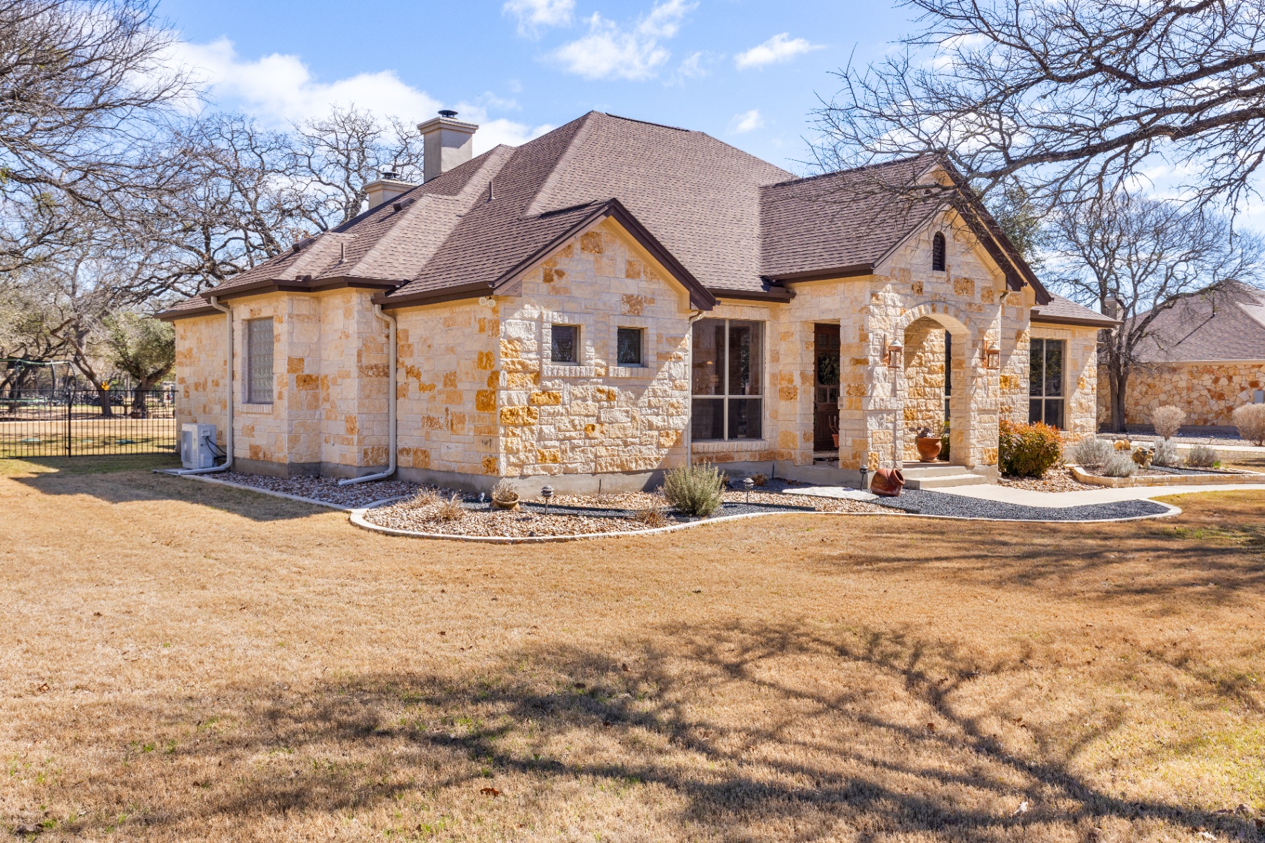Side exterior view showing stone facade and landscaping