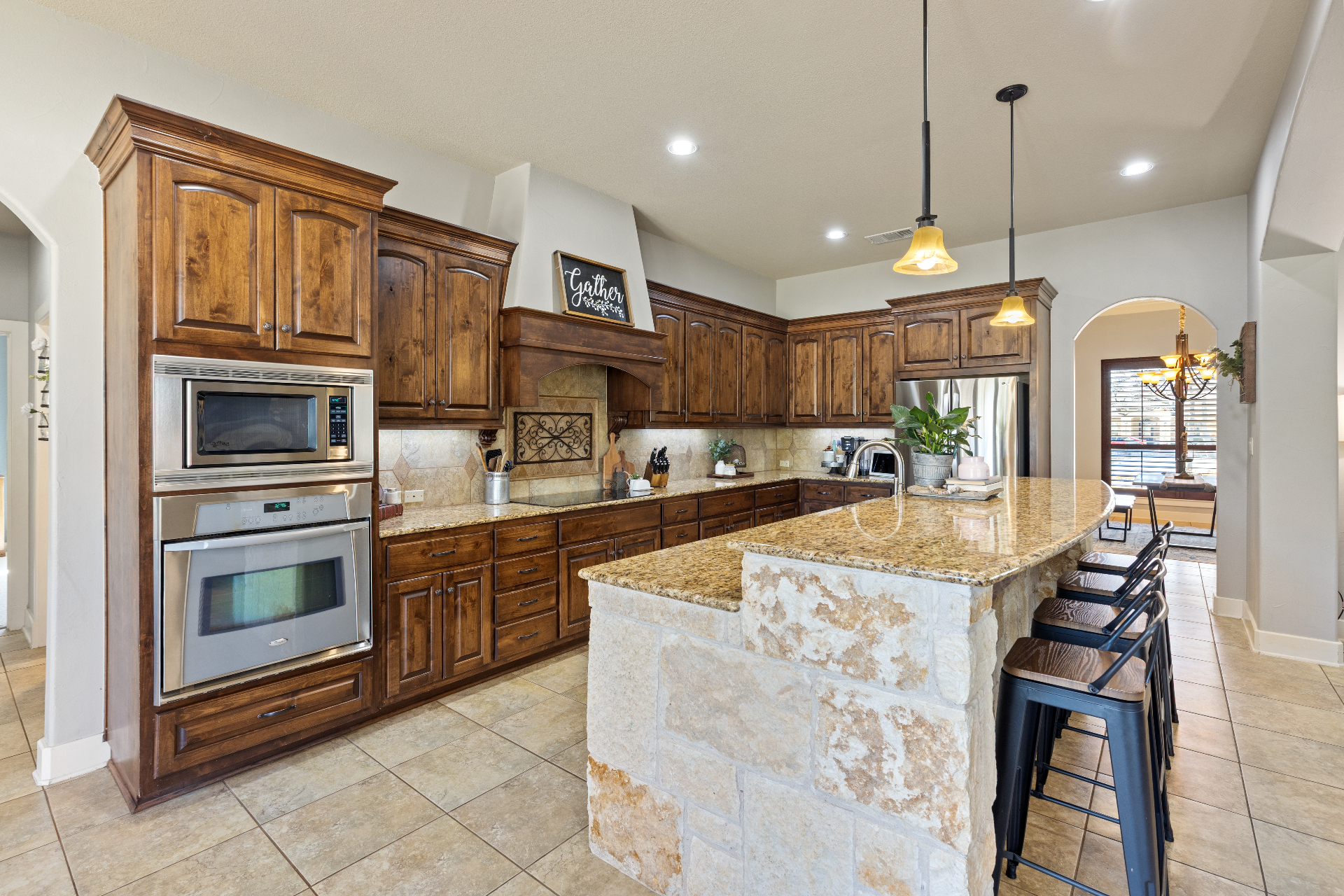 Kitchen angle showing double ovens and custom vent hood